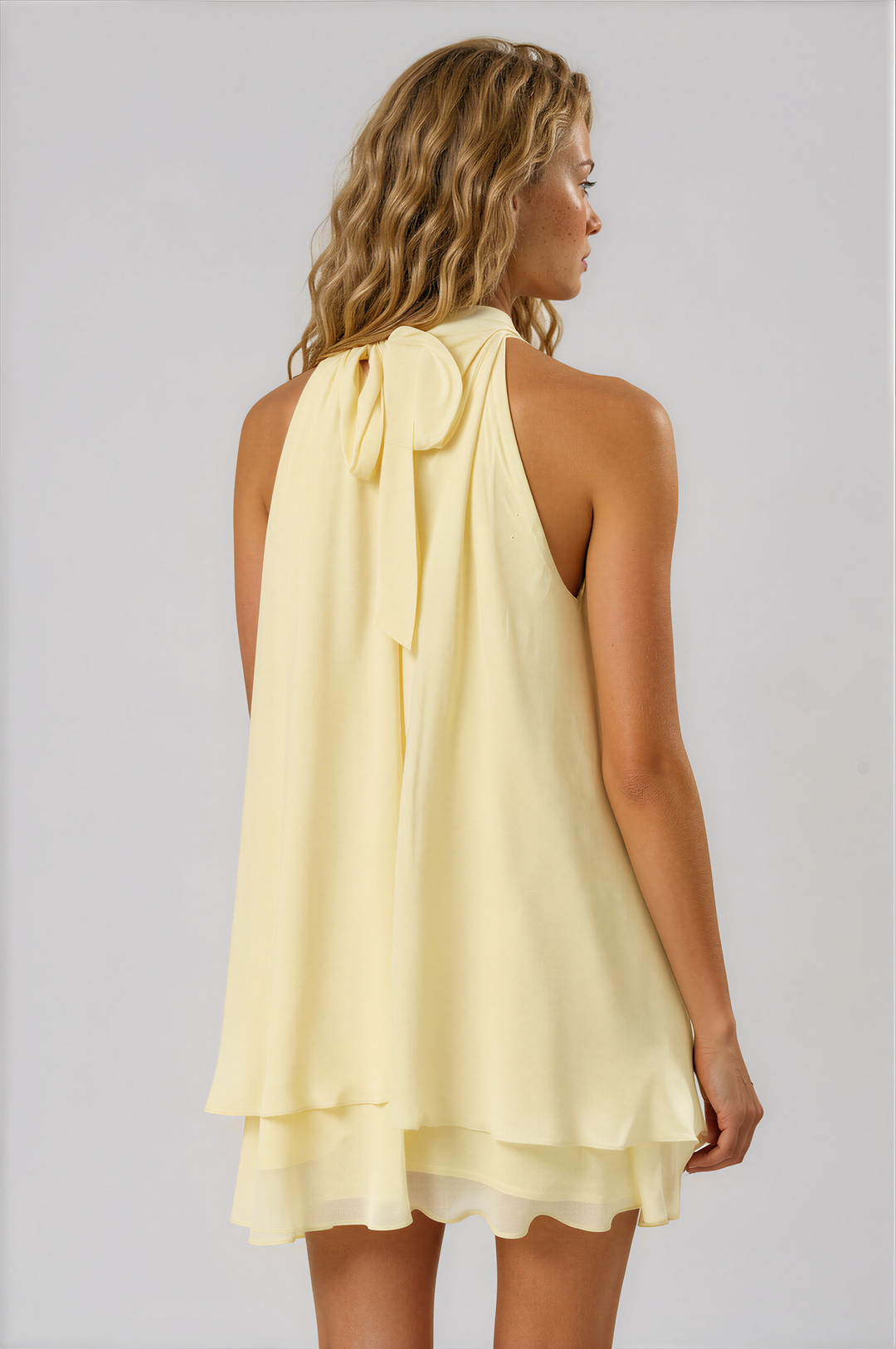 woman wearing a flowy pale yellow mini dress