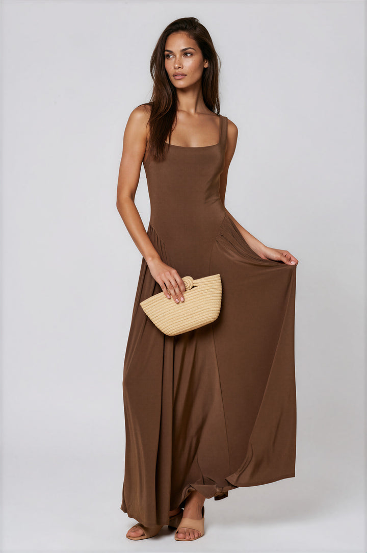 Woman wearing brown jersey maxi dress with square neckline and flowing skirt