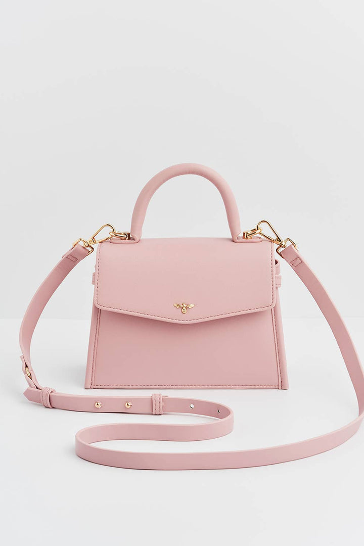 Pink handbag with a matching strap on a light gray background