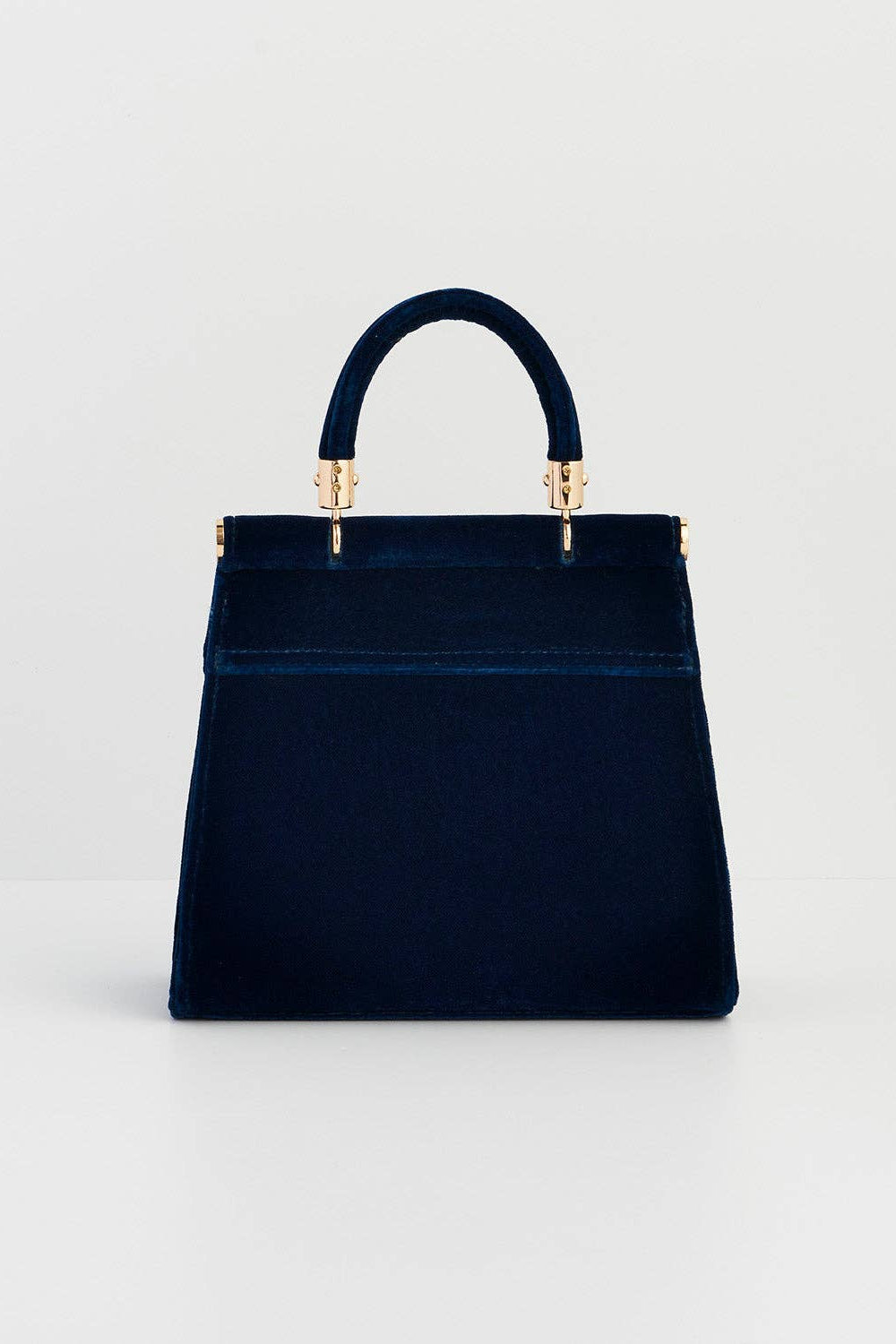 Navy blue handbag with gold accents on a light gray background