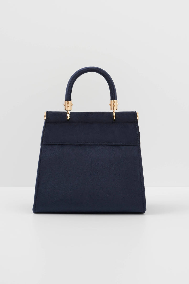 Navy handbag with gold accents on a light gray background
