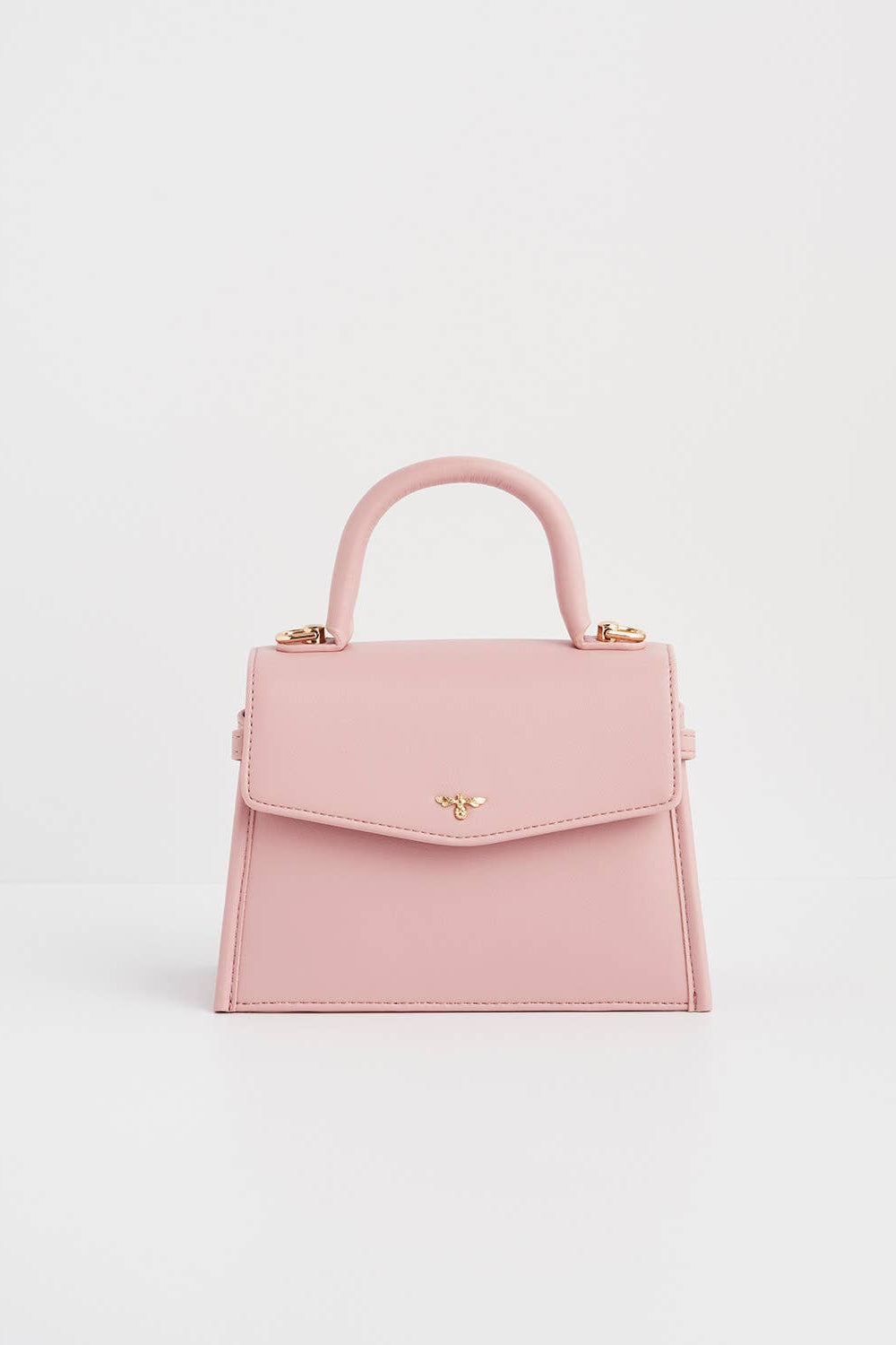 Pink handbag with a gold clasp on a light gray background