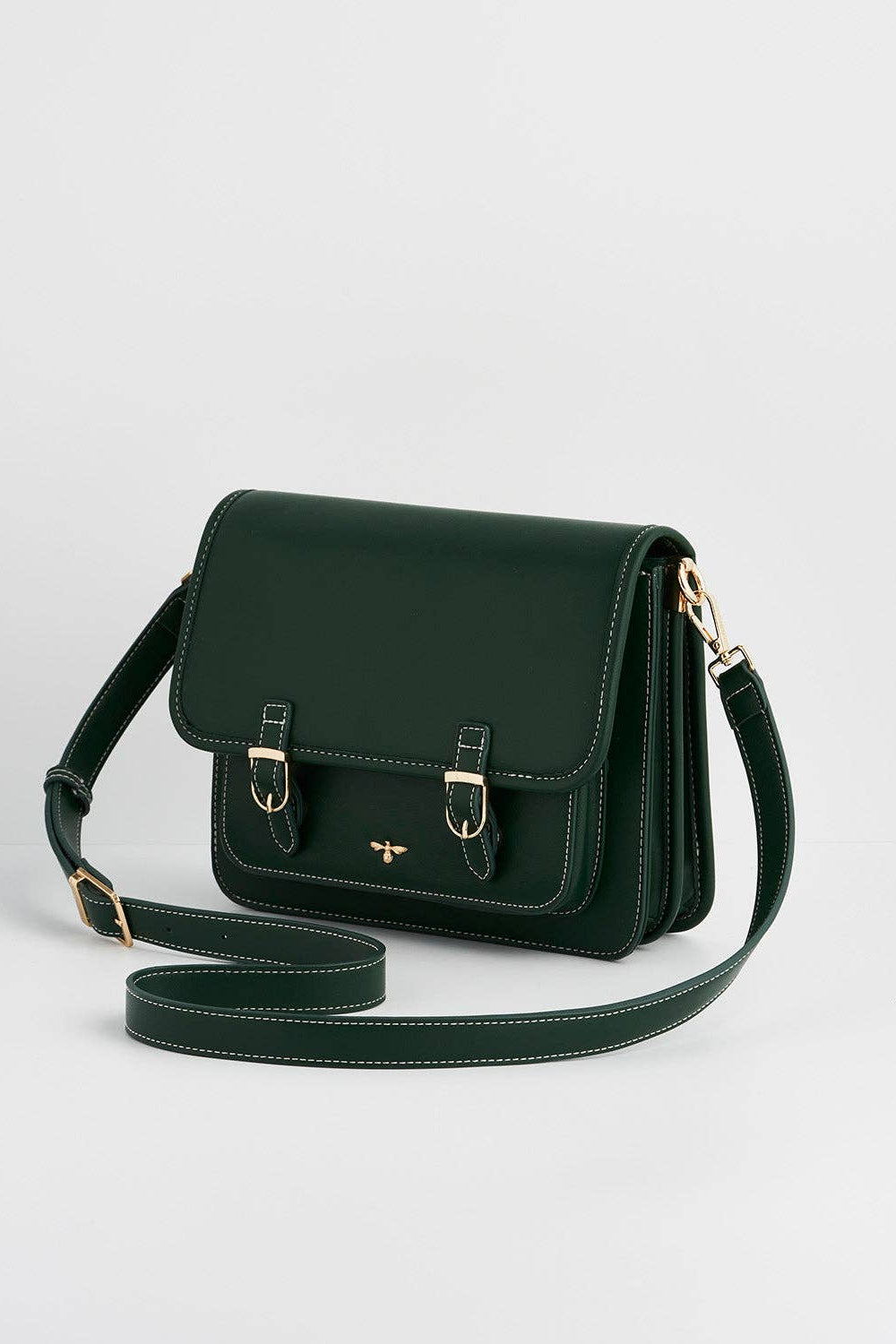 Green leather handbag with a strap on a light gray background