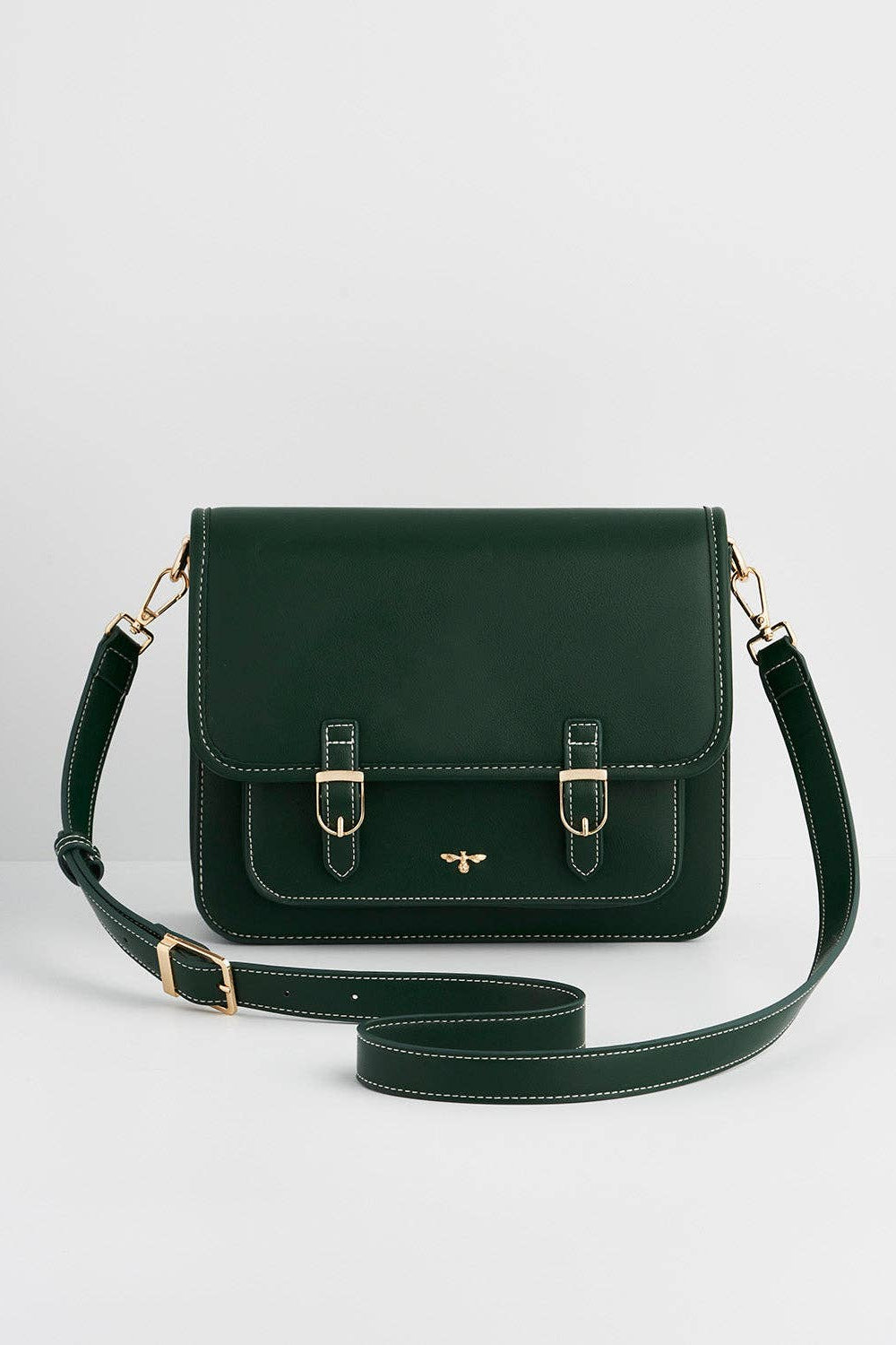 Green leather handbag with gold accents on a light gray background