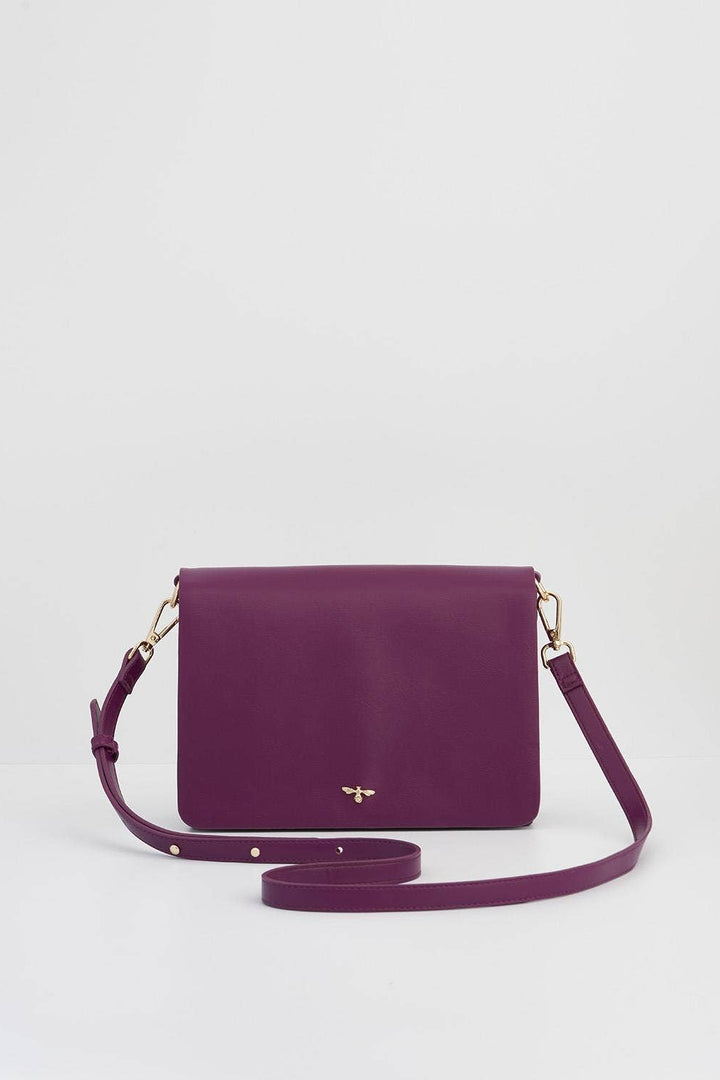 Purple handbag with a strap on a light gray background