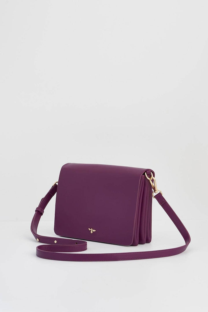 Purple handbag with a gold clasp on a light gray background