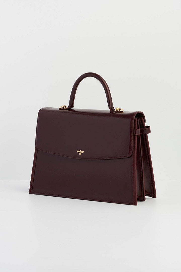 Brown handbag with a gold clasp on a light gray background