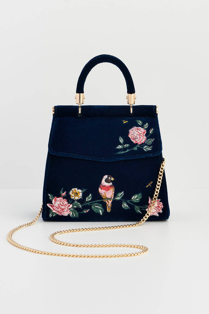 Navy blue handbag with floral and bird embroidery on a light gray background