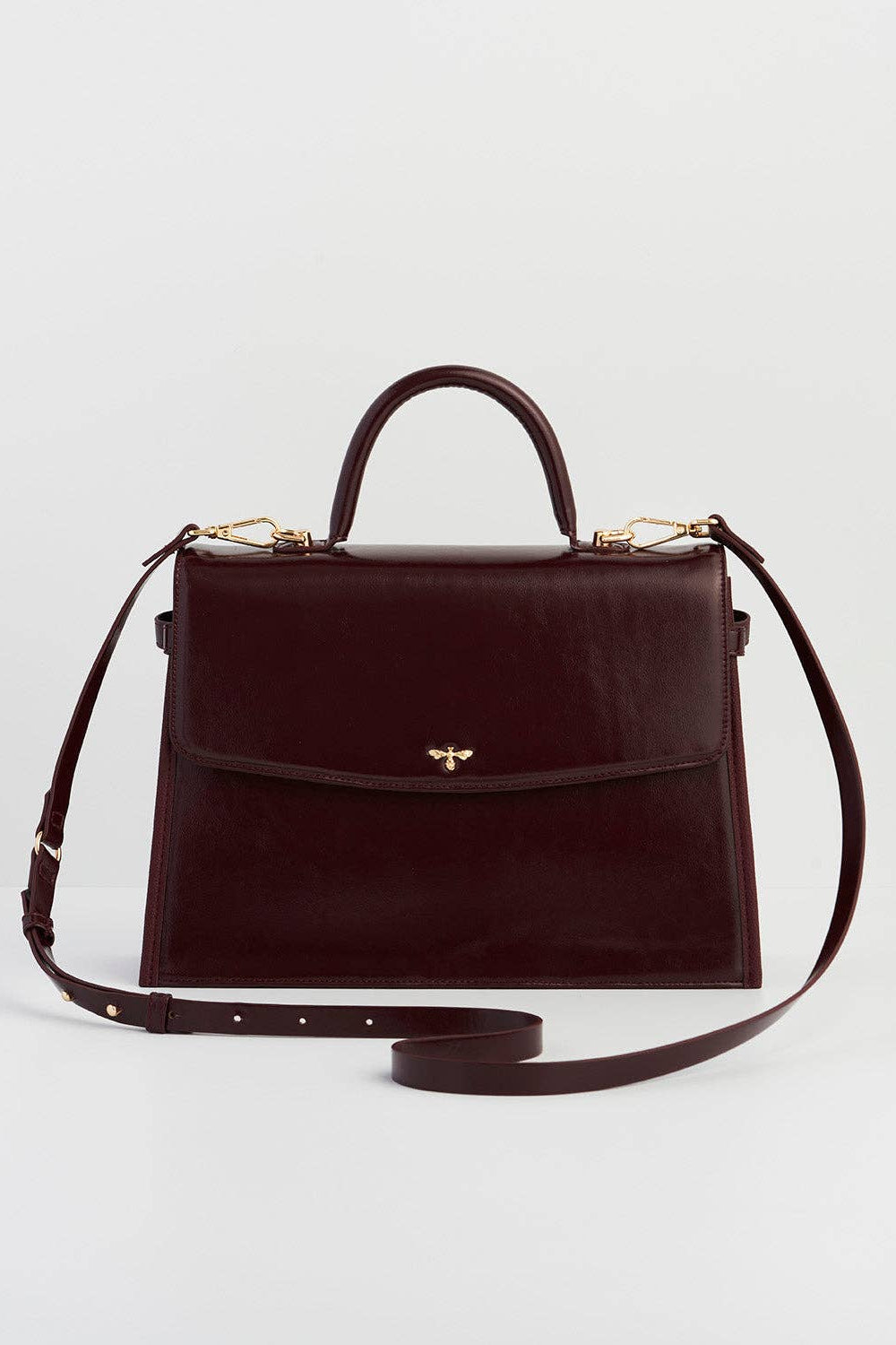 Brown handbag with a strap on a light gray background