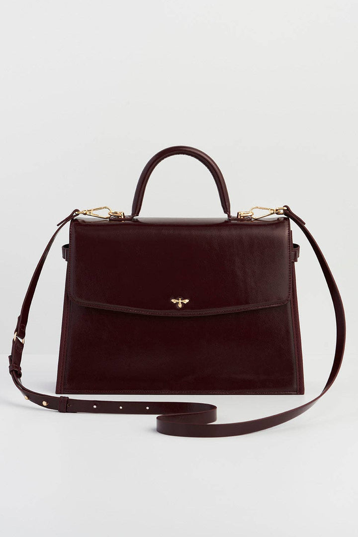 Brown handbag with a strap on a light gray background