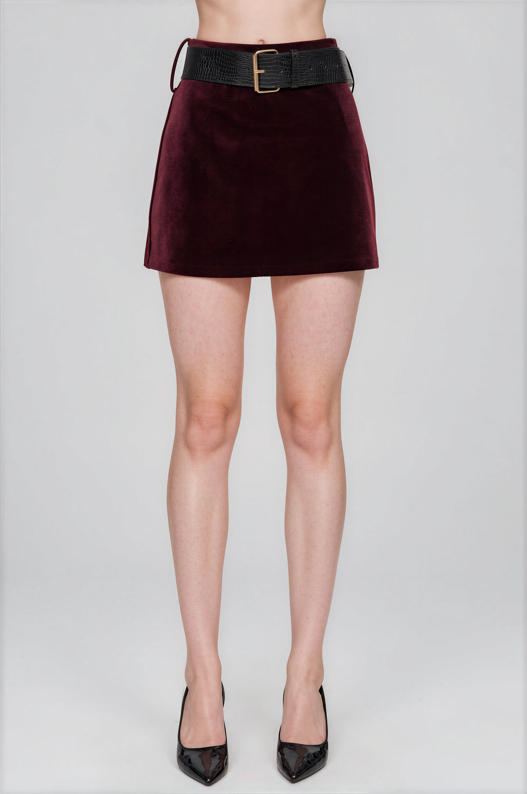 Burgundy velvet mini skort with a crocodile-textured belt