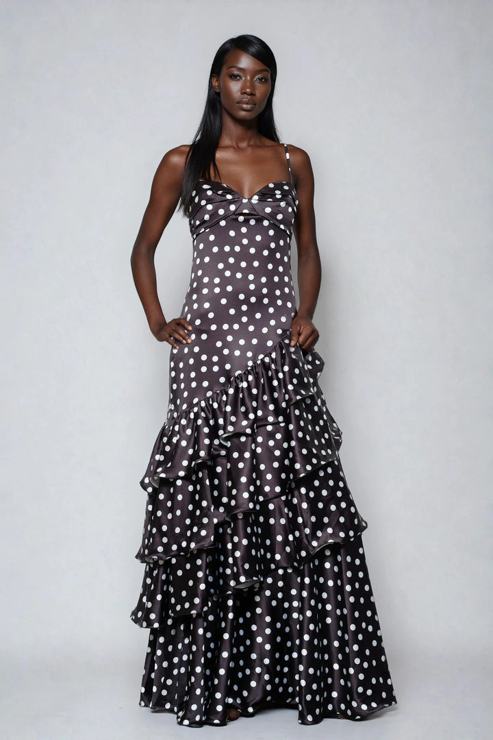 Woman wearing a black and white polka dot dress on a plain background