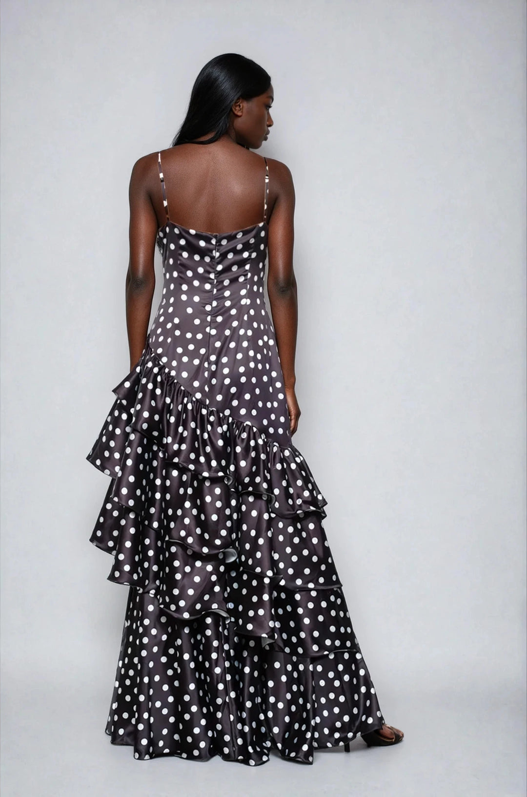 Woman wearing a black polka dot dress against a white background