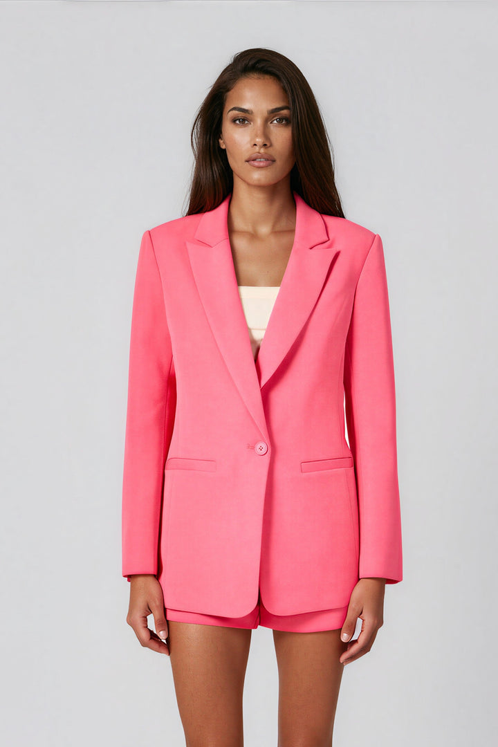 Woman wearing pink single-breasted blazer with skinny lapel over matching shorts