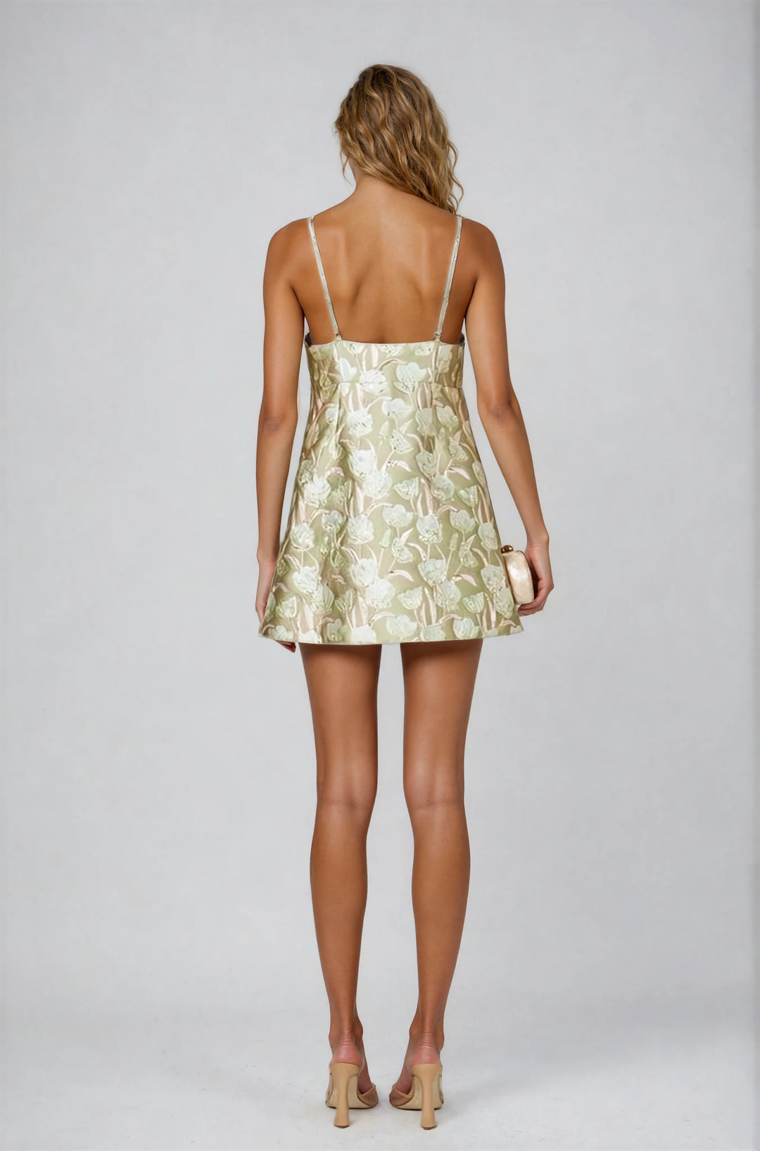 Woman wearing a gold floral dress on a white background