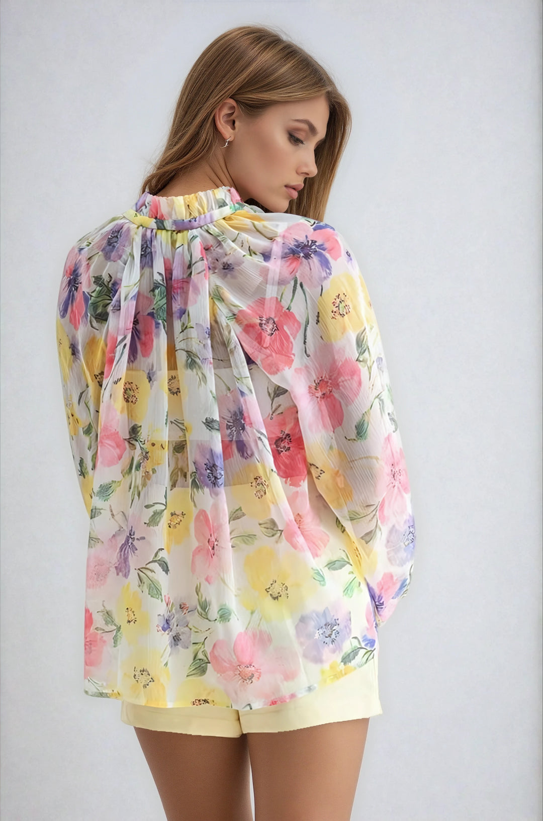 Woman wearing a colorful floral blouse against a plain background