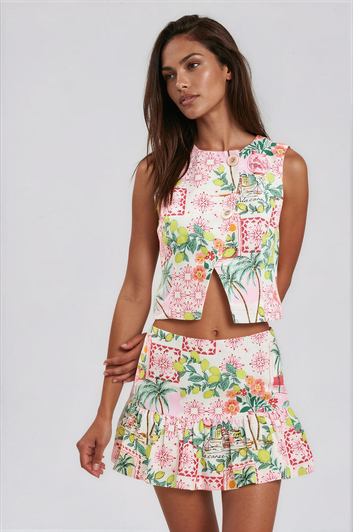 Woman wearing tropical-print sleeveless vest crop top and matching ruffle skort set