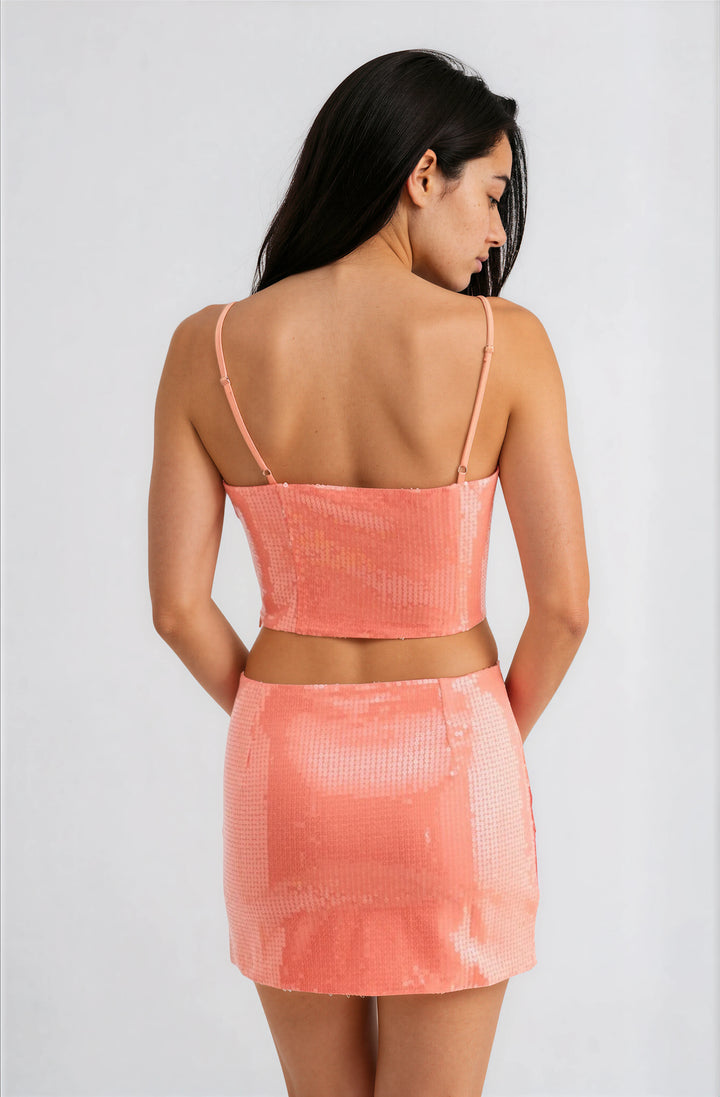woman wearing pink and orange sequin matching skirt set