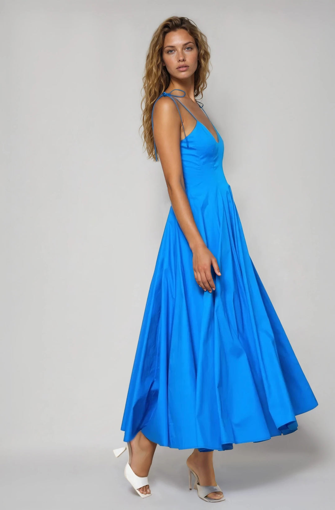 Woman wearing a blue dress on a gray background
