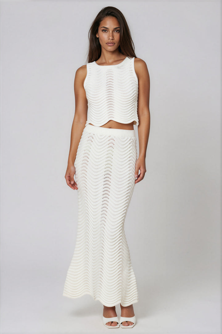 Woman wearing off-white open-knit sleeveless crop top and maxi skirt set