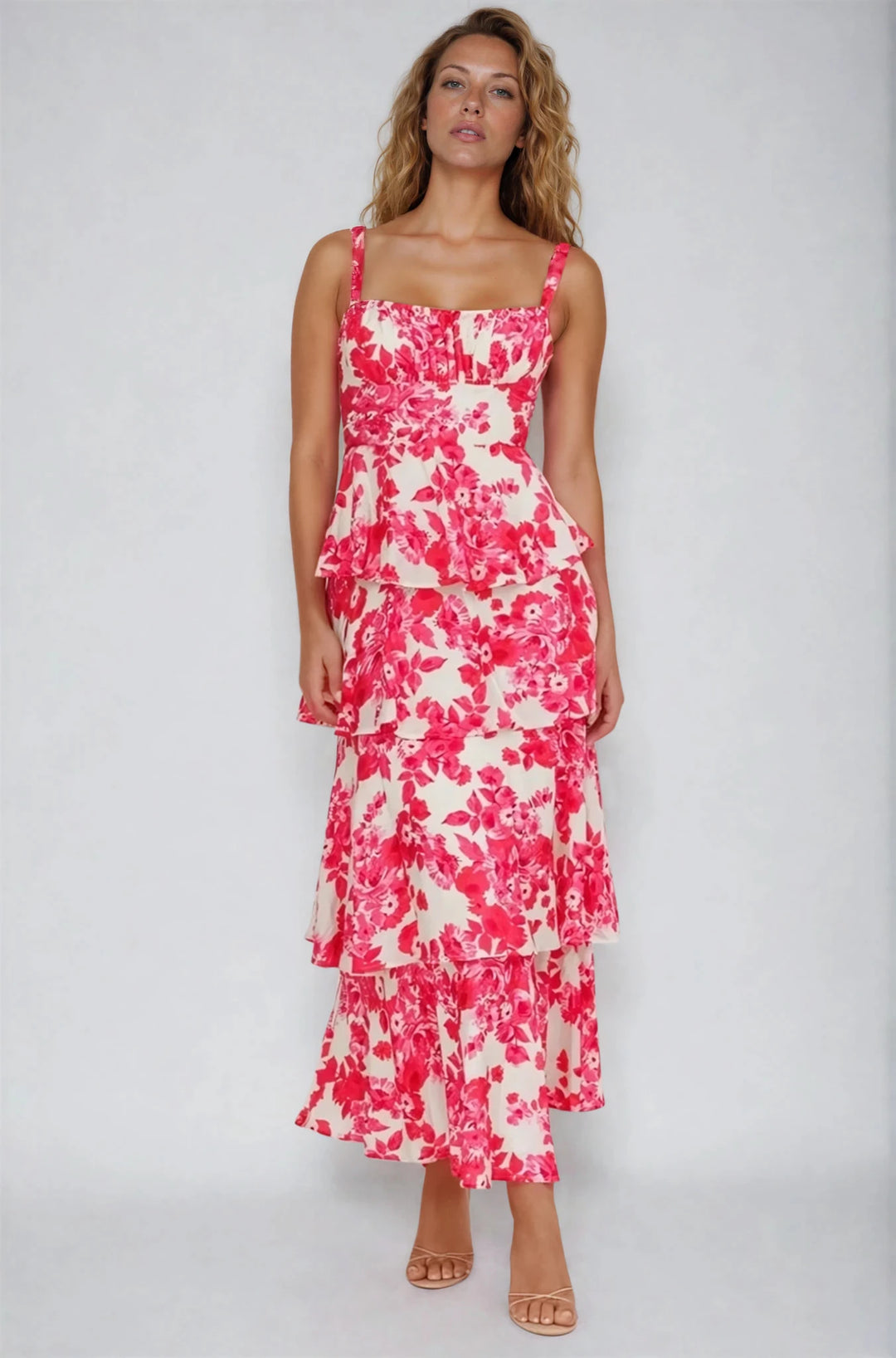 Woman wearing a pink and white floral dress on a plain background