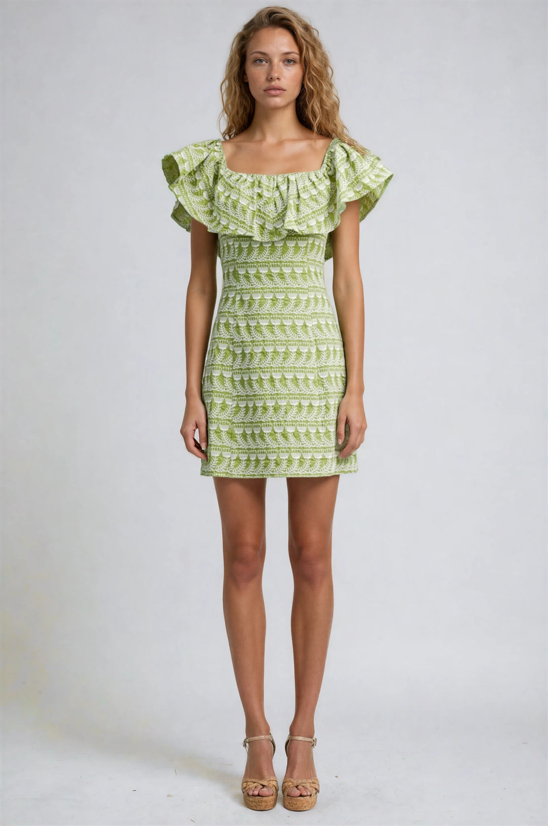 Woman wearing a green patterned dress on a white background