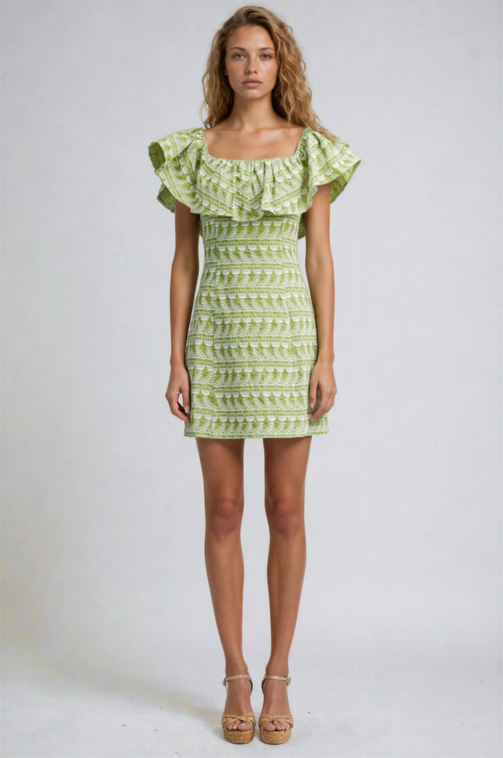 Woman wearing a green patterned dress on a white background