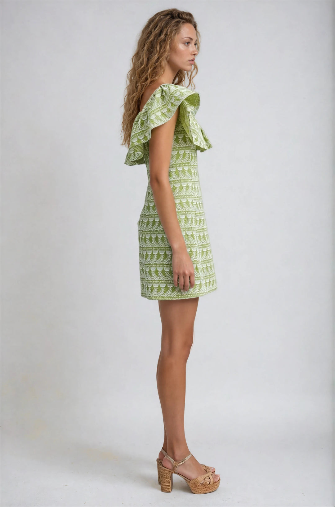Woman wearing a green patterned dress on a white background