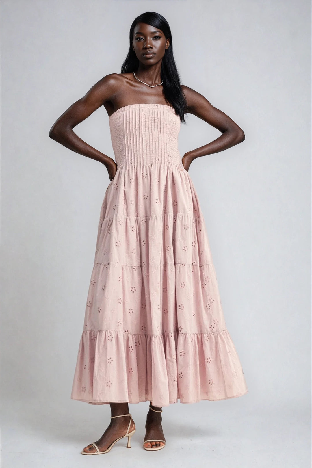 Woman wearing a pink strapless dress with a white background