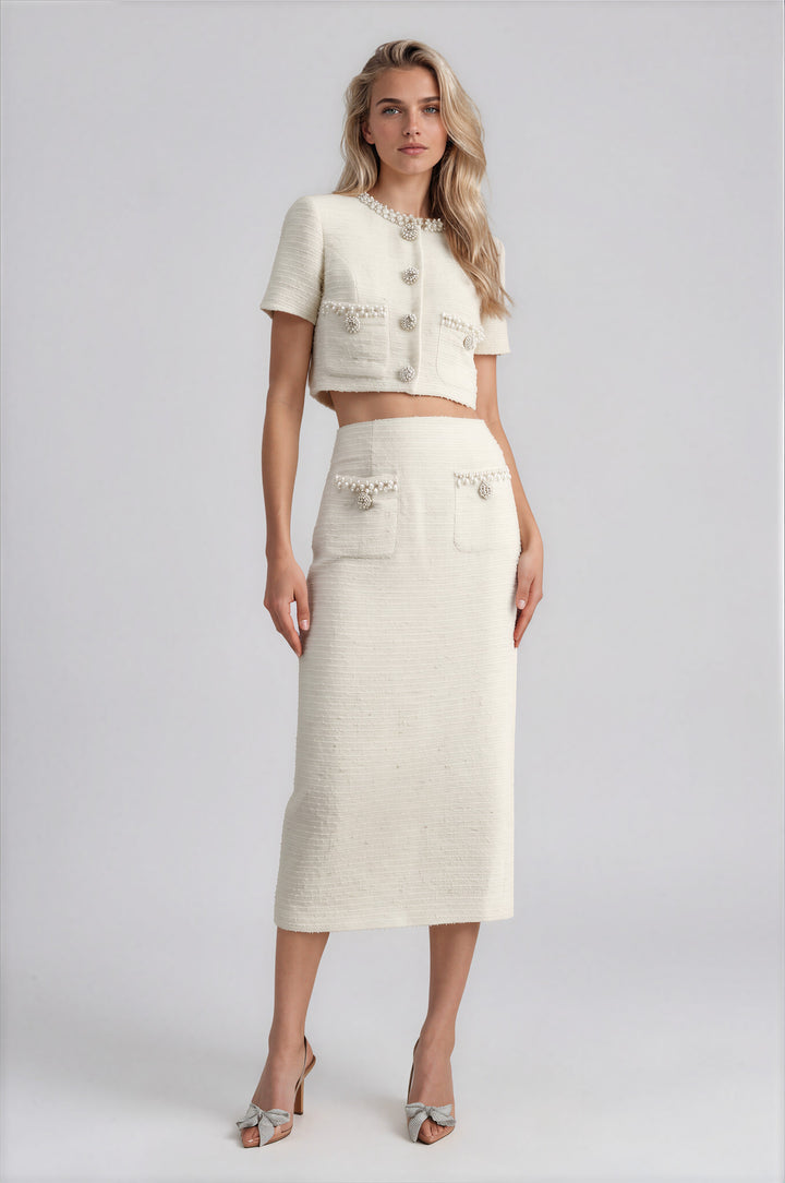 Woman wearing cream tweed cropped jacket and midi skirt set with jewel trim