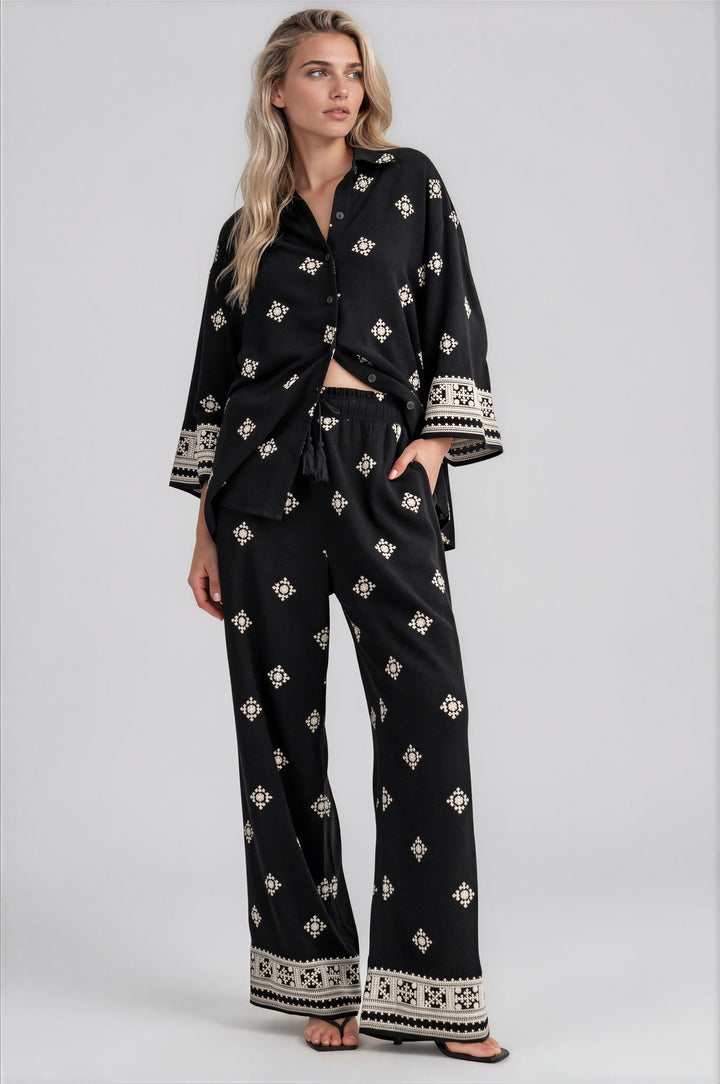 Woman wearing black and cream embroidered button-down shirt and wide-leg pants set
