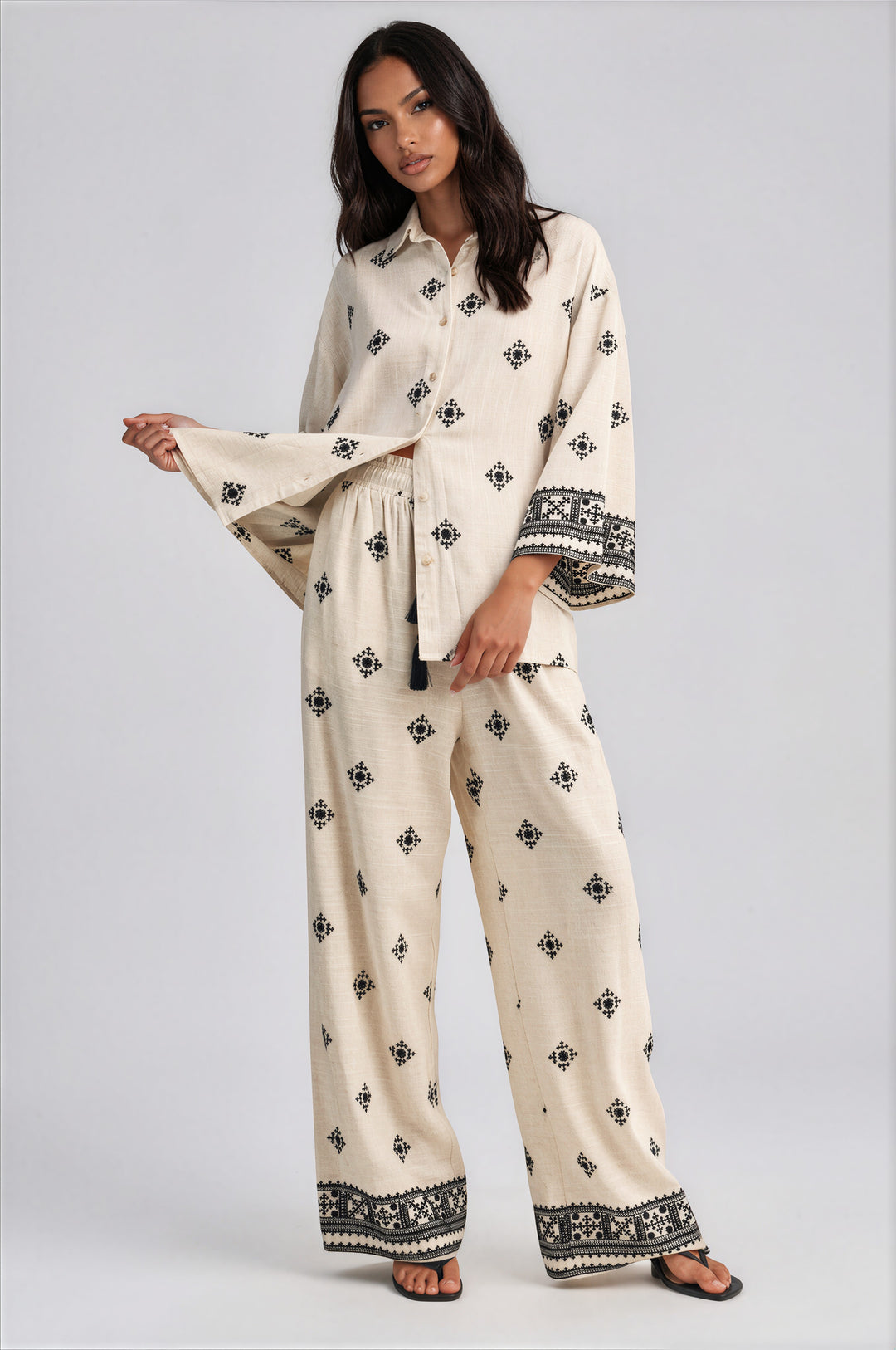 Cream wide leg pants set with black geometric embroidery and oversized button front collared top