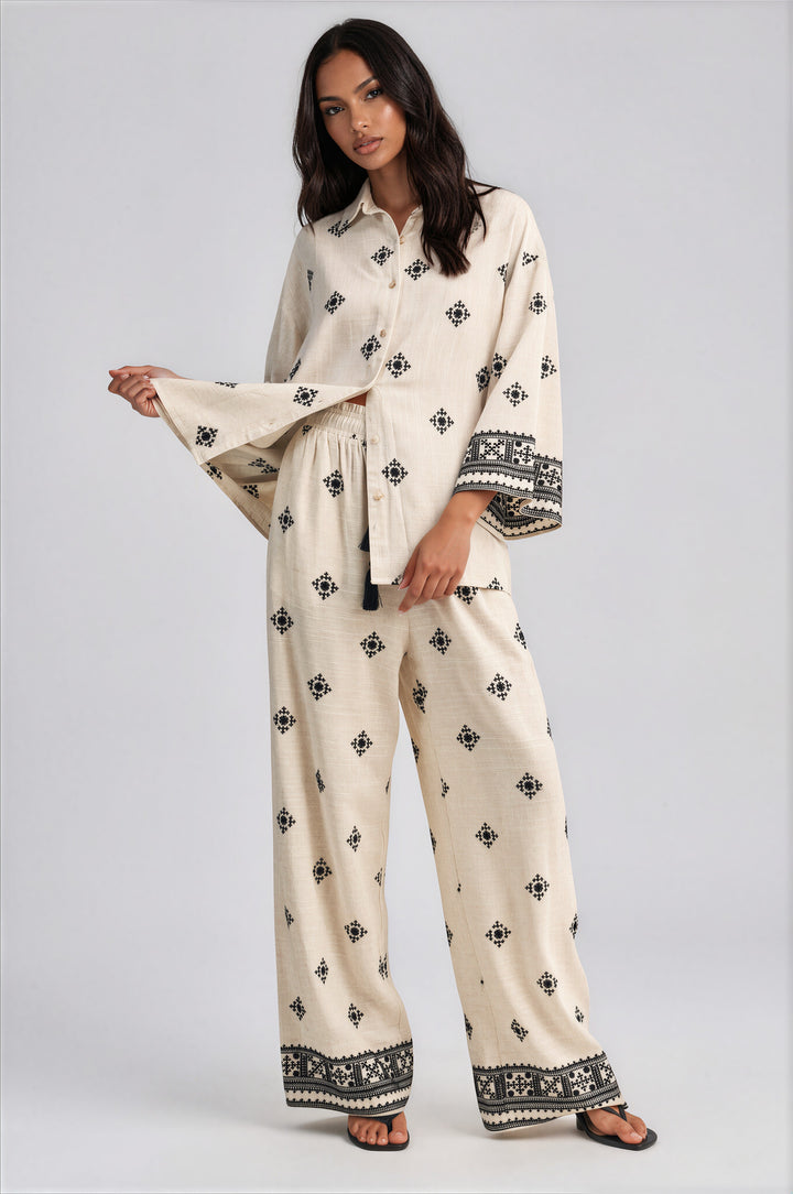 Cream wide leg pants set with black geometric embroidery and oversized button front collared top