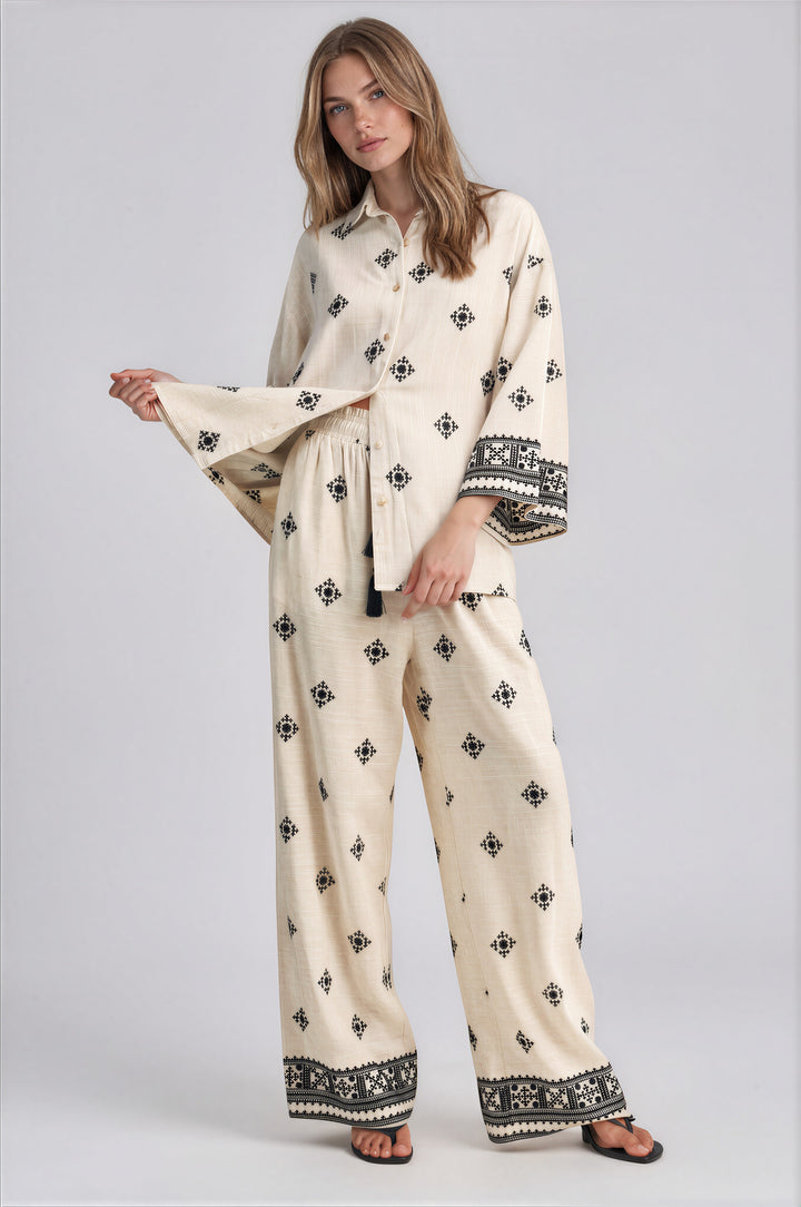 Cream wide leg pants set with black geometric embroidery and oversized button front collared top