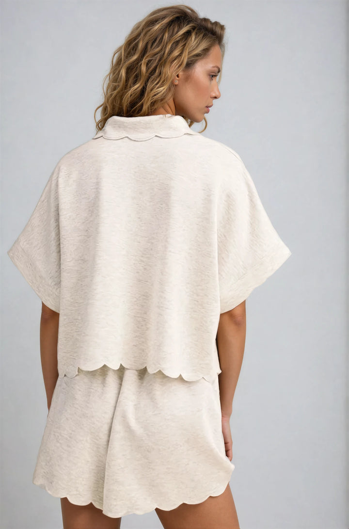 Woman wearing a beige layered outfit against a gray background