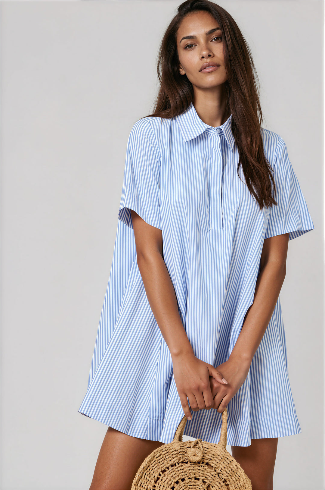 Woman wearing blue and white striped short sleeve collared A-line shirt dress