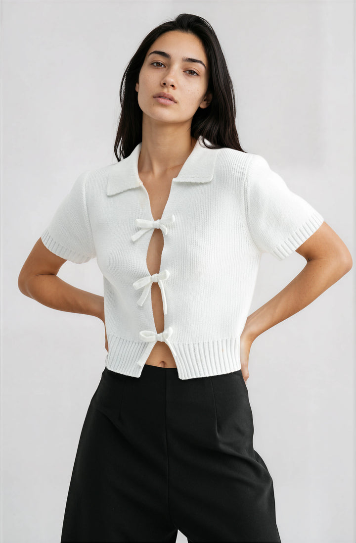 woman wearing white short sleeve knit top with bow cutout detail