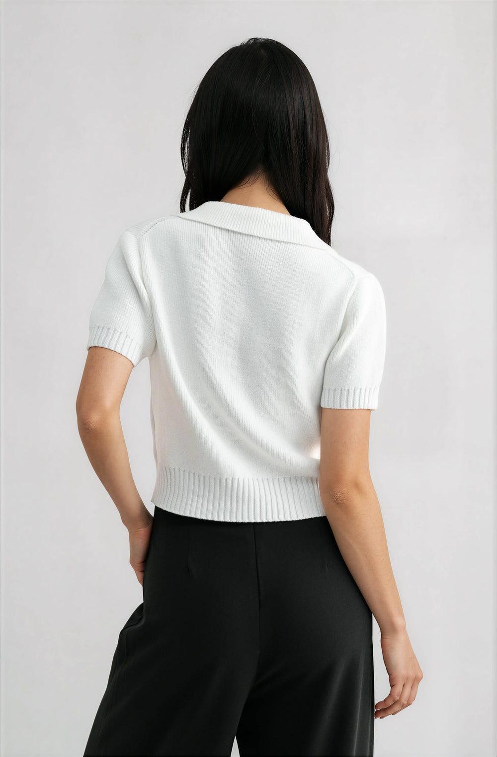 woman wearing white short sleeve knit top with bow cutout detail