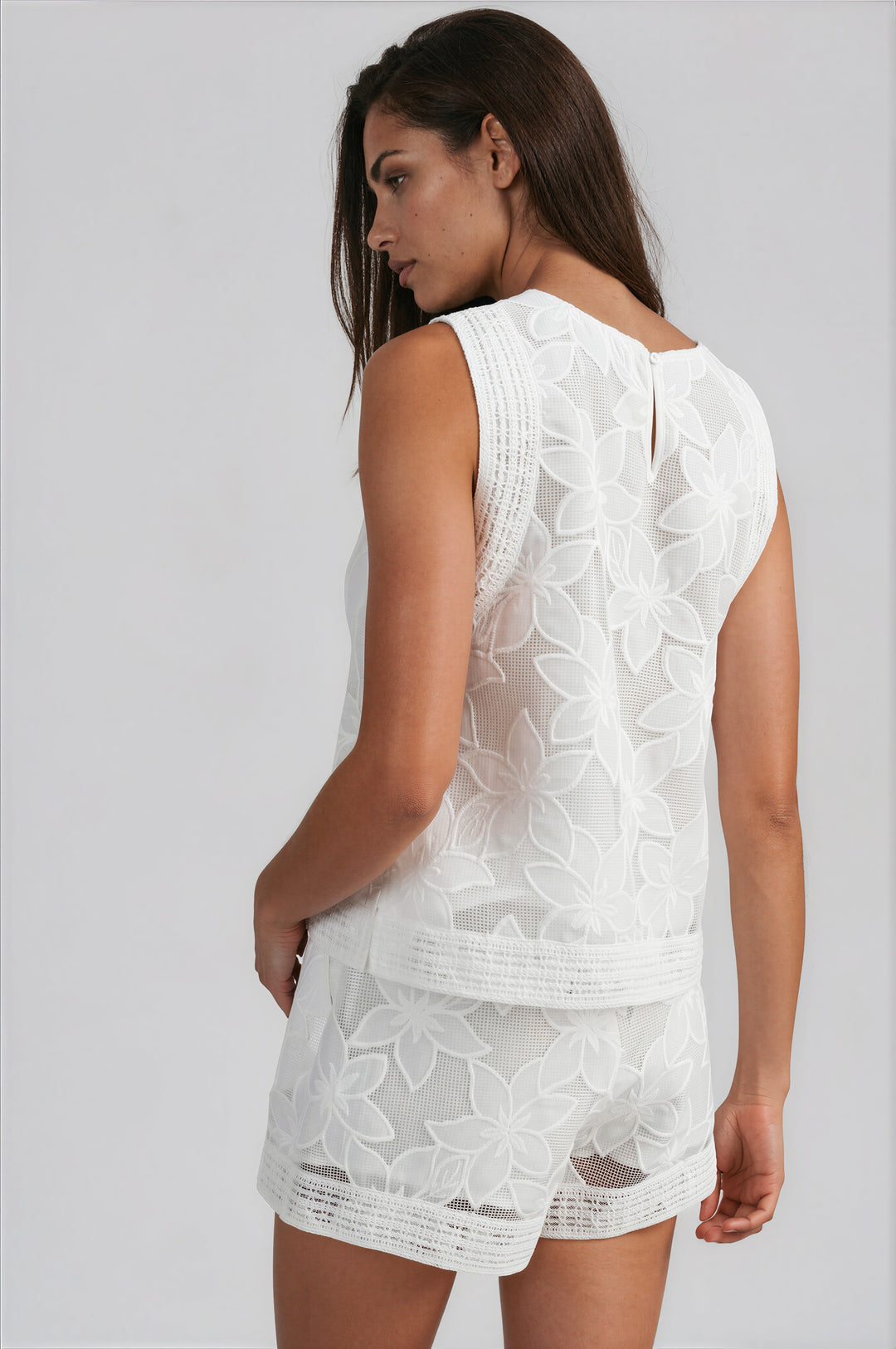 woman wearing white floral lace shorts set