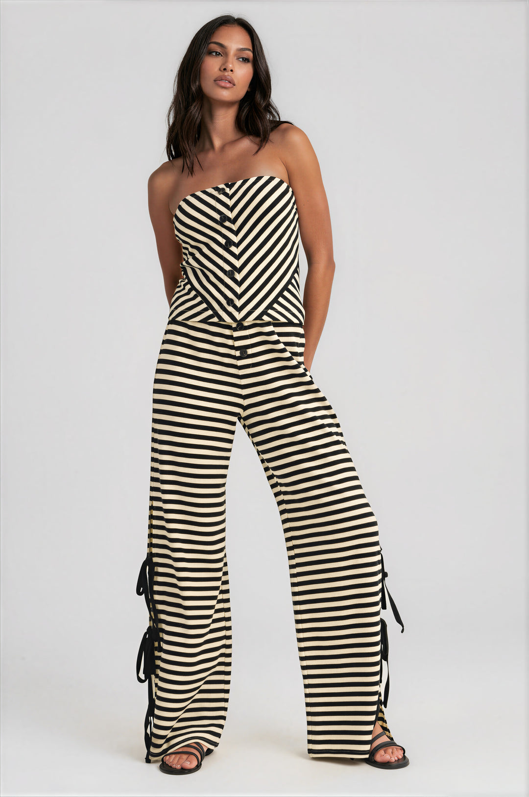 Woman wearing black and cream striped strapless top and wide-leg pants set