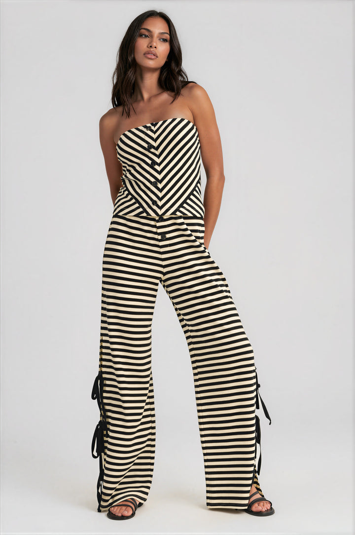 Woman wearing black and cream striped strapless top and wide-leg pants set