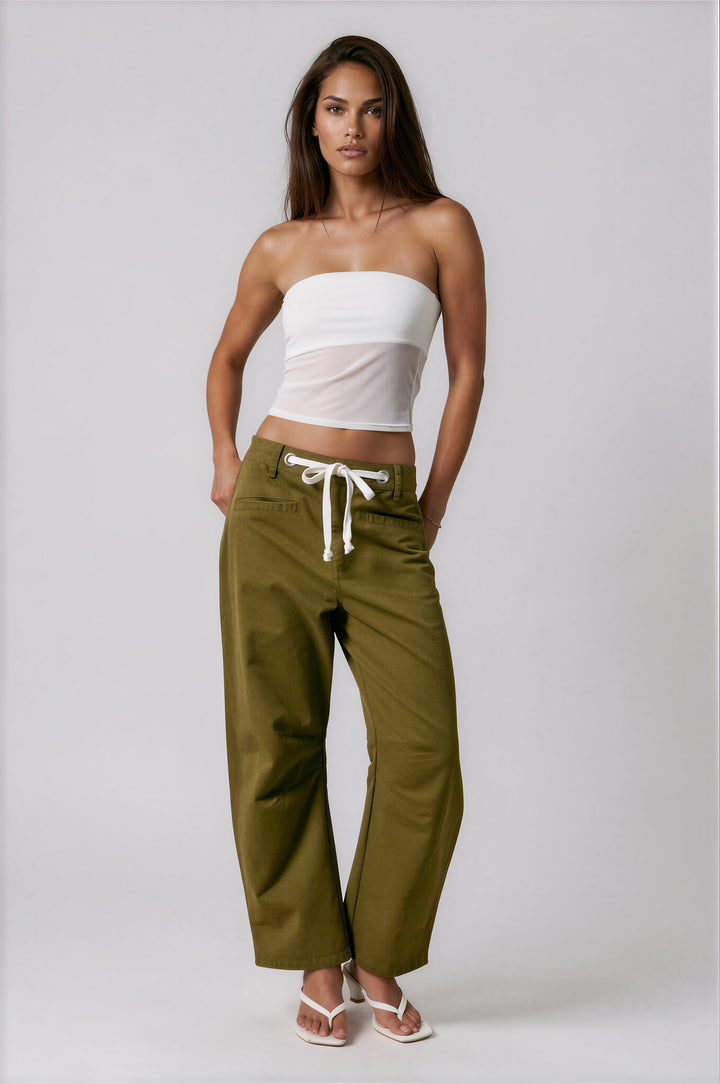 Woman wearing olive low-rise barrel-leg pants with white drawstring waist