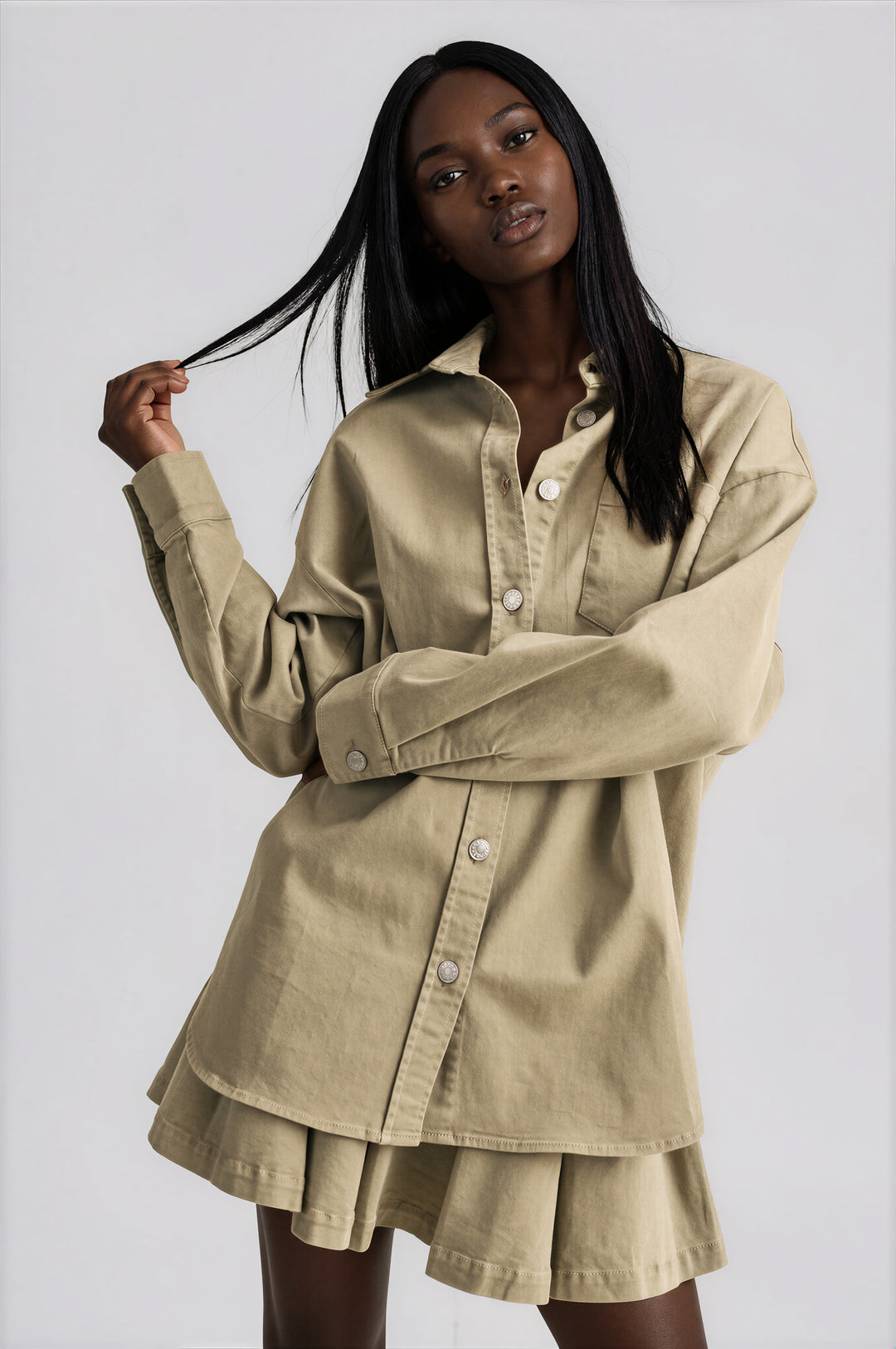 Olive cotton set with an oversized button-down shirt and pleated mini skirt, front view