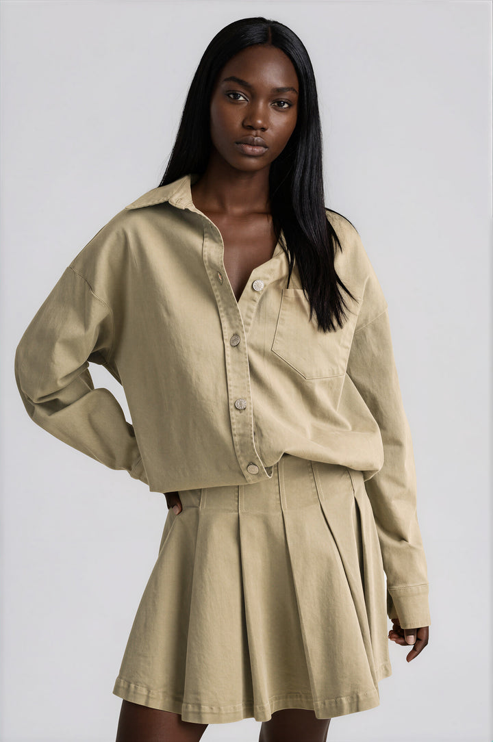 Olive cotton button-down shirt with a collar and chest pocket, and matching pleated skirt