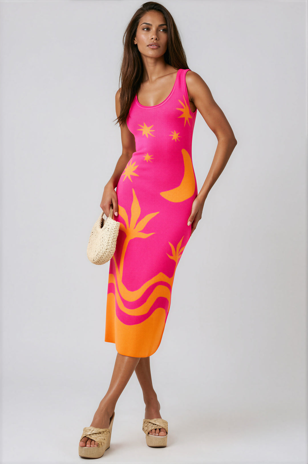 Woman wearing hot pink sleeveless knit midi dress with tropical star and moon print