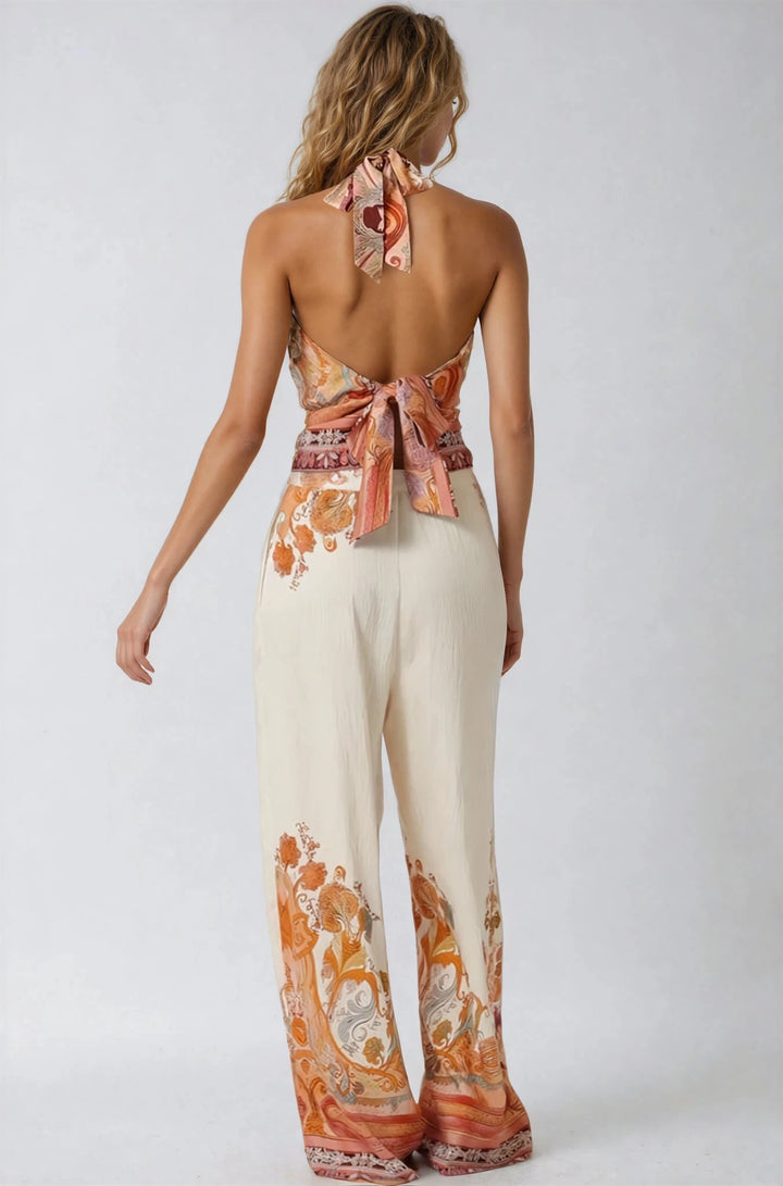 Woman wearing a patterned top and pants on a white background