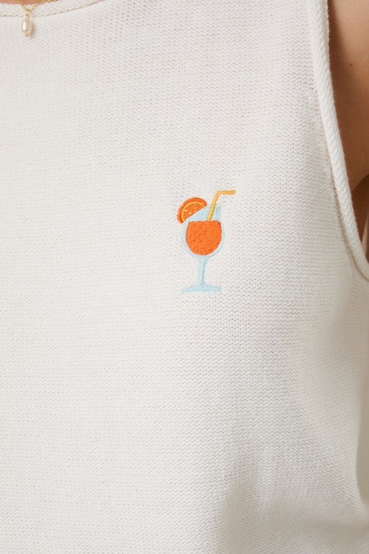 white sleeveless sweater top with embroidered spritz detail close up of emblem