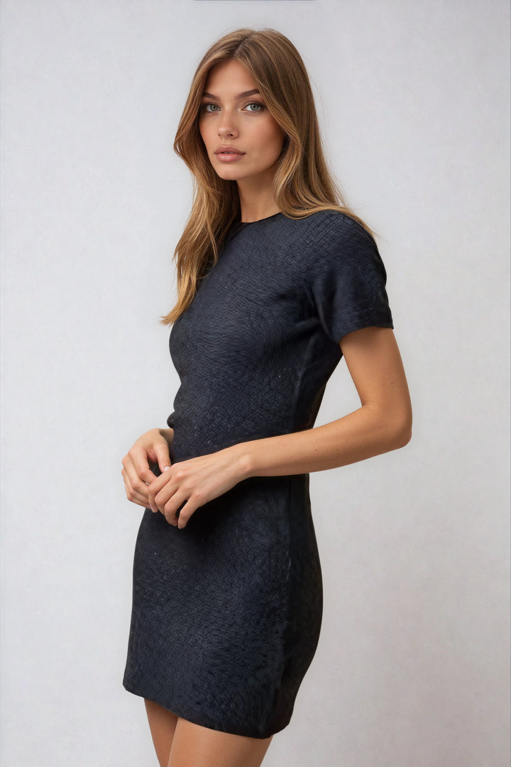 Woman wearing a dark blue dress against a plain background