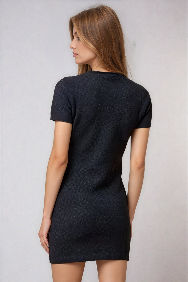 Woman wearing a black t-shirt dress against a plain background