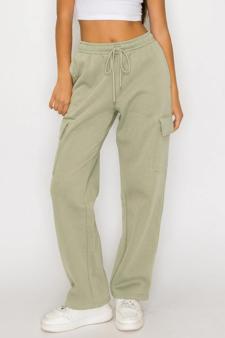 Person wearing olive green jogger pants on a white background